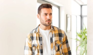 Yakışıklı bir adam üzgün, üzgün ya da kızgın. Olumsuz bir tavır sergiliyor, anlaşmazlık içinde kaşlarını çatıyor.