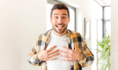 Yakışıklı adam mutlu görünüyor, şaşırmış, gururlu ve heyecanlı, kendini gösteriyor.