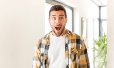 Yakışıklı adam korkmuş ve şok olmuş hissediyor, ağzı açık şaşkınlık içinde.