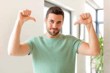 Yakışıklı bir adam gururlu, kibirli ve kendinden emin, tatmin olmuş ve başarılı görünüyor, kendini gösteriyor.