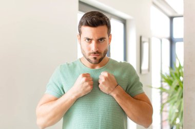 Yakışıklı, kendine güvenen, sinirli, güçlü ve agresif bir adam. Yumrukları boks pozisyonunda dövüşmeye hazır.