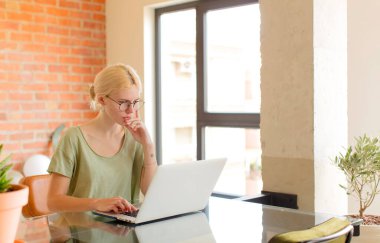Profil görünümündeki güzel öğrenci boşluğu kopyalamaya çalışıyor, düşünüyor, hayal ediyor ya da hayal kuruyor.