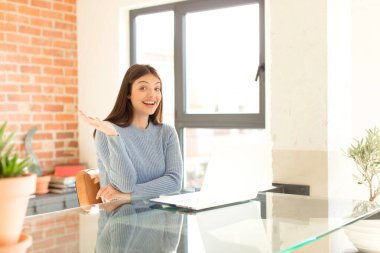 Güzel bir kadın mutlu, şaşırmış ve neşeli, pozitif bir tavırla gülümseyen, bir çözüm ya da fikir gerçekleştiren.
