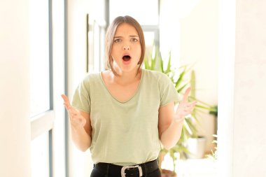 Güzel bir kadın ağzı açık ve şaşırmış, şok olmuş ve hayrete düşmüş.