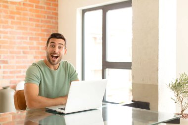 Yakışıklı adam mutlu ve hoş bir şekilde şaşırmış görünüyor. Büyülenmiş ve şok olmuş bir ifadeyle heyecanlanıyor.