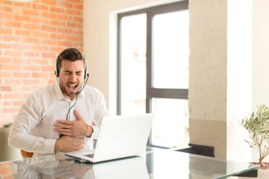 Yakışıklı pazarlamacı komik bir şakaya gülüyor, mutlu ve neşeli hissediyor, eğleniyor.