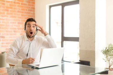 Yakışıklı pazarlamacı mutlu, şaşkın ve şaşırmış görünüyor, gülümsüyor ve inanılmaz ve inanılmaz iyi haberleri fark ediyor.