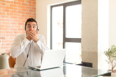 Yakışıklı pazarlamacı elleri ile ağzını kapatıyor, şok olmuş, şaşırmış bir ifadeyle, bir sır saklıyor ya da 