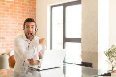 Yakışıklı pazarlamacı mutlu, pozitif ve başarılı hissediyor, bir meydan okumayla karşılaştığında motive oluyor veya iyi sonuçları kutluyor.