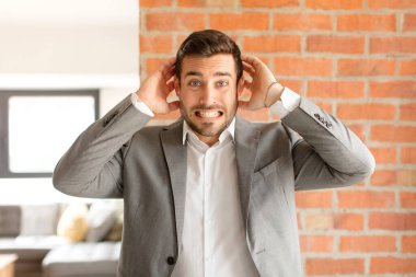 Yakışıklı iş adamı stresli, endişeli, endişeli ya da korkmuş hissediyor, elleri başının üstünde, hata yaptığında panikliyor.