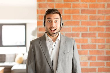 Yakışıklı pazarlamacı mutlu ve hoş bir şekilde şaşırmış görünüyor. Büyülenmiş ve şok olmuş bir ifadeyle heyecanlanıyor.