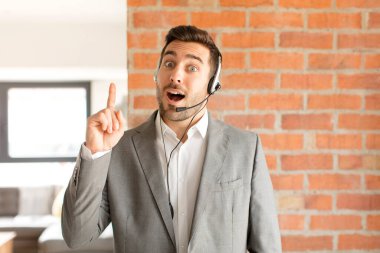 Yakışıklı bir pazarlamacı bir fikri fark ettikten sonra mutlu ve heyecanlı bir dahi gibi hisseder, neşeli bir şekilde parmağını kaldırır, eureka!