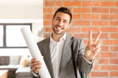 Yakışıklı mimar gülümsüyor ve mutlu görünüyor, kaygısız ve olumlu, zafer ya da barışı simgeliyor.