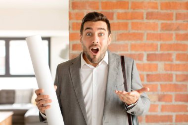 Yakışıklı mimar ağzı açık ve şaşırmış, şok olmuş ve hayretler içinde kalmış.