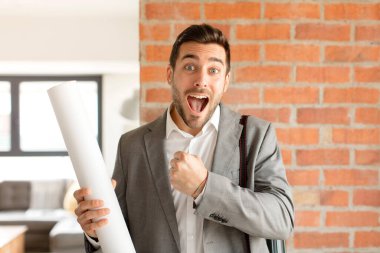 Yakışıklı mimar mutlu, pozitif ve başarılı hissediyor, bir meydan okumayla karşılaştığında motive oluyor veya iyi sonuçları kutluyor.