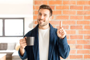 Yakışıklı bir adam gülümsüyor ve arkadaş canlısı görünüyor. Bir numara ya da ilk eli önde, geriye doğru sayıyor.