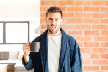 Yakışıklı bir adam tiksinmiş ve rahatsız olmuş hissediyor. Dilini dışarı çıkarıyor. Çirkin ve iğrenç bir şeyden hoşlanmıyor.