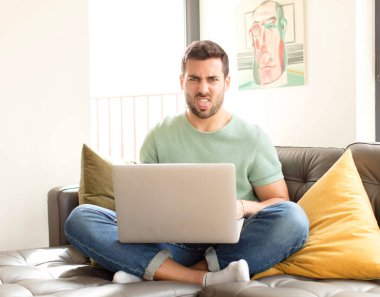 Yakışıklı bir adam tiksinmiş ve rahatsız olmuş hissediyor. Dilini dışarı çıkarıyor. Çirkin ve iğrenç bir şeyden hoşlanmıyor.