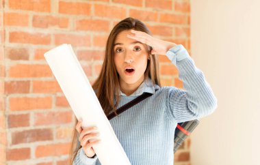 Güzel mimar mutlu, şaşkın ve şaşırmış görünüyor, gülümsüyor ve inanılmaz ve inanılmaz iyi haberleri fark ediyor.