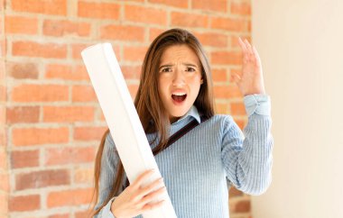 Güzel mimar elleri havada bağırıyor. Öfkeli, sinirli, stresli ve üzgün.