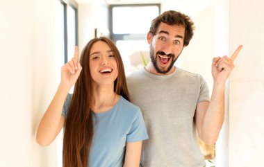 Genç çift bir fikri fark ettikten sonra mutlu ve heyecanlı bir dahi gibi hissediyorlar, neşeli bir şekilde parmak kaldırıyorlar, eureka!