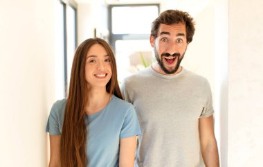 Genç çift mutlu ve hoş bir şekilde şaşırmış görünüyor. Büyülenmiş ve şok olmuş bir ifadeyle heyecanlanıyorlar.