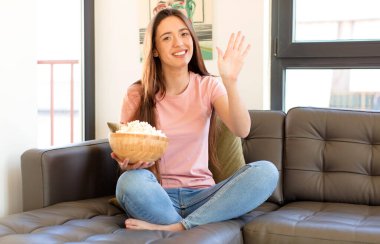 Gülümsüyor ve dost canlısı görünüyor, 5 ya da 5 numarayı gösteriyor, el önde, geriye doğru sayıyor.