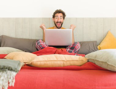 Genç sakallı adam şok olmuş, heyecanlı ve mutlu hissediyor, gülüyor ve başarıyı kutluyor,!