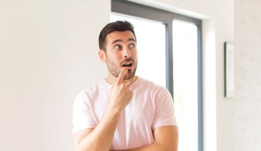 Şaşırmış, gergin, endişeli ya da korkmuş bakışları olan yakışıklı bir adam.