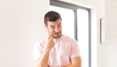 Yakışıklı adam sana göz kulak oluyor, güvenmiyor, izliyor, tetikte ve tetikte.