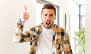 Kızgın agresif bir ifadeyle kameraya bakan yakışıklı bir adam kızgın, çılgın bir patron gibi görünüyor.