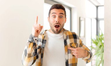 Yakışıklı bir adam gururlu ve şaşırmış, kendine güvenen, kendini bir numara gibi hisseden.