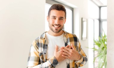 Yakışıklı adam romantik, mutlu ve aşık, neşeyle gülümseyen ve kalbe yakın el ele tutuşan