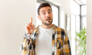 Yakışıklı bir adam, harika bir fikri fark ettikten sonra parmağını havaya kaldırıp 