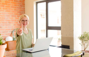 Güzel öğrenci gururla gülümsüyor ve gururla bir numaralı poz veriyor, kendini lider gibi hissediyor.