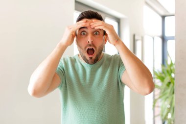 Yakışıklı adam dehşete kapılmış ve şok olmuş hissediyor, ellerini havaya kaldırıyor ve hata yaptığında panikliyor.