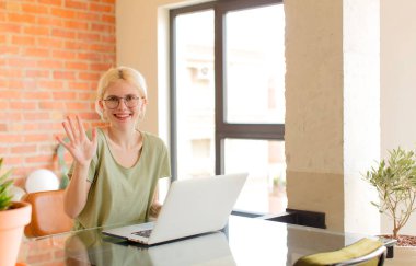 Güzel bir öğrenci gülümsüyor ve arkadaş canlısı görünüyor, 5 ya da 5 numarayı gösteriyor, elleri önde, geriye doğru sayıyor.