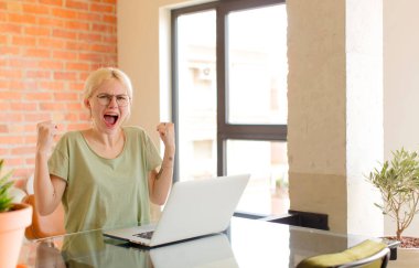 Güzel öğrenci sinirli bir ifadeyle ya da yumruklarıyla başarıyı kutlarken agresif bir şekilde bağırıyor.