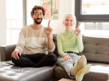 Genç çift gülümsüyor ve arkadaş canlısı görünüyor. Bir numara ya da ilk eli önde, geriye doğru sayıyor.