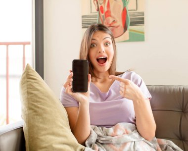 Güzel bir kadın heyecanlı ve şaşırmış görünüyor. Yana ve yukarı doğru uzayı gösteriyor.