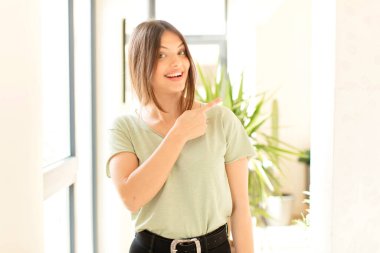 Güzel bir kadın heyecanlı ve şaşırmış görünüyor. Yana ve yukarı doğru uzayı gösteriyor.