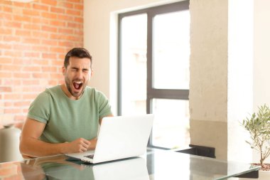 Yakışıklı adam agresif bir şekilde bağırıyor, sinirli, sinirli, öfkeli ya da sinirli görünüyor.