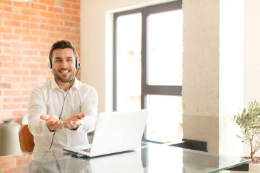 Yakışıklı tele pazarlamacı gülerek güler yüzlü, kendine güvenen, olumlu bakışlı, bir nesne ya da konsept sunan