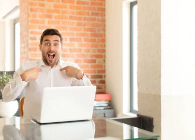 Yakışıklı iş adamı mutlu, şaşkın ve gururlu, heyecanlı, şaşkın bakışlarla kendini işaret ediyor.