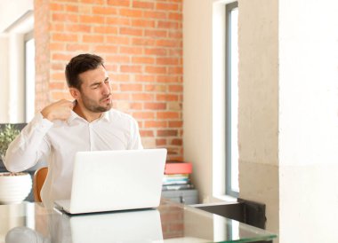 Yakışıklı iş adamı stresli, endişeli, yorgun ve hayal kırıklığına uğramış, gömleğini çekmiş, sıkıntılı görünüyor.