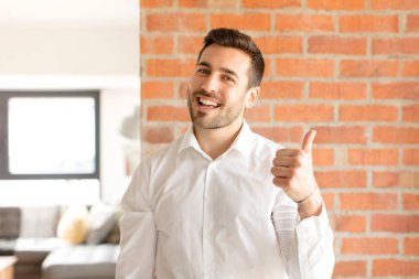 Yakışıklı iş adamı gururlu, kaygısız, kendinden emin ve mutlu, olumlu gülümsüyor.