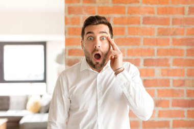 Yakışıklı işadamı şaşırmış, ağzı açık, şok olmuş, yeni bir düşünce, fikir ya da konsept keşfediyor.