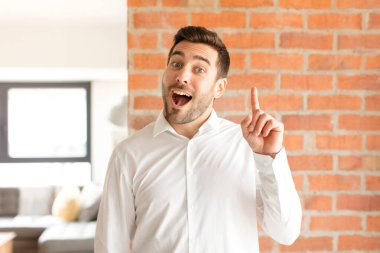 Yakışıklı iş adamı bir fikri fark ettikten sonra mutlu ve heyecanlı bir dahi gibi hisseder, neşeli bir şekilde parmağını kaldırır, eureka!