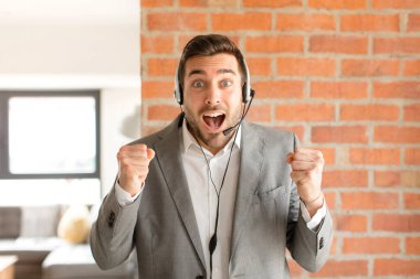 Yakışıklı pazarlamacı şok olmuş, heyecanlı ve mutlu hissediyor, gülüyor ve başarıyı kutluyor,!