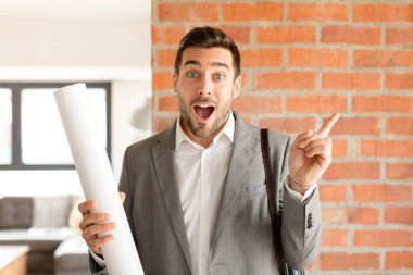 Yakışıklı mimar heyecanlı ve şaşırmış görünüyor. Yana ve yukarı doğru uzayı gösteriyor.